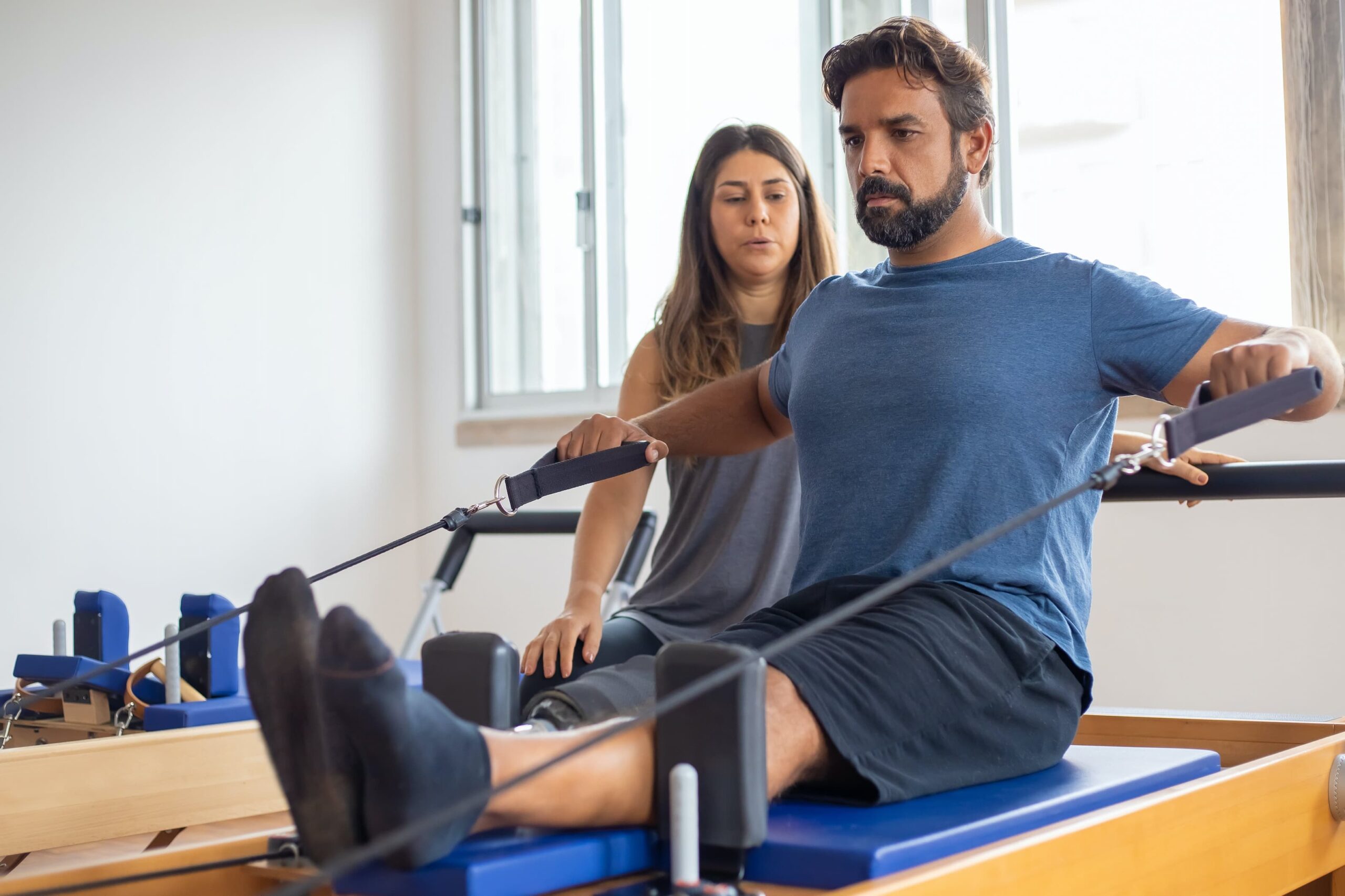 Man with trainer on pilates machine